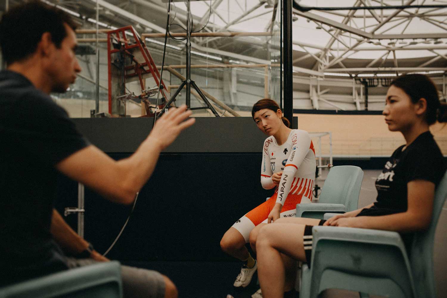 Japanese track cyclist discuss performance with Biomechanist during training session at velodrome