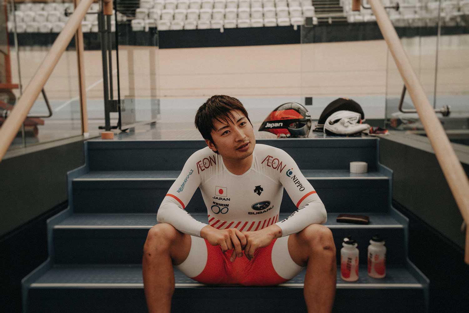 Japanese cyclist sits down after training in velodrome to discuss performance